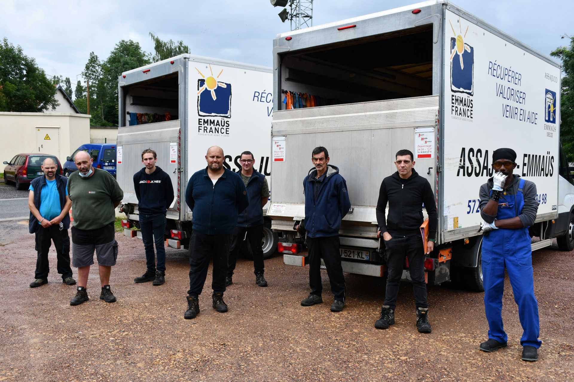 Travailleurs en insertion devant les camions de transport